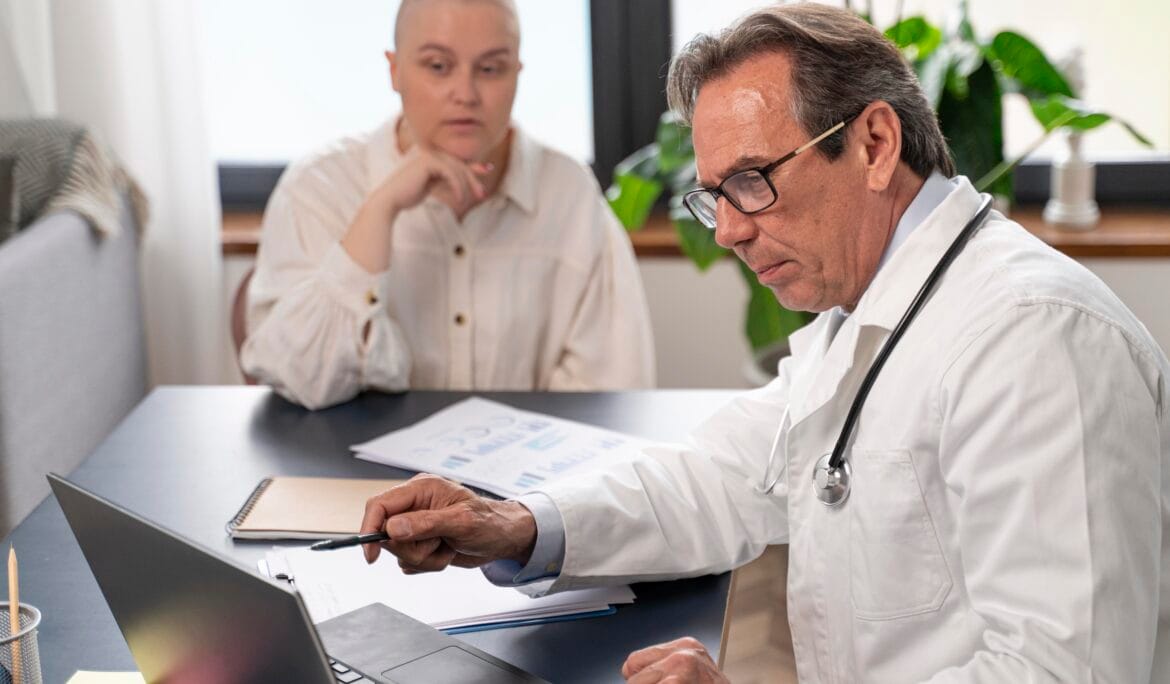 A-bald-woman-discusses-chronic-care-management-with-her-doctor